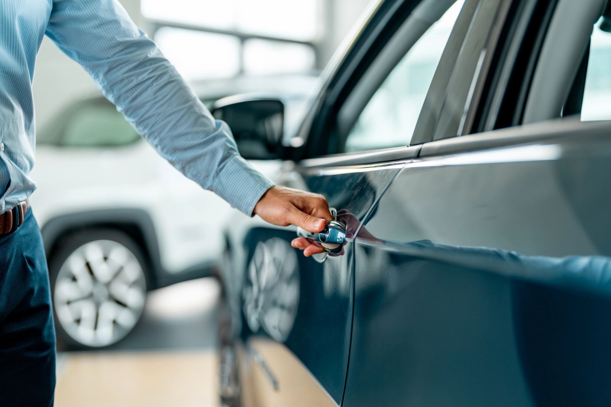Person opening a car door at a dealership