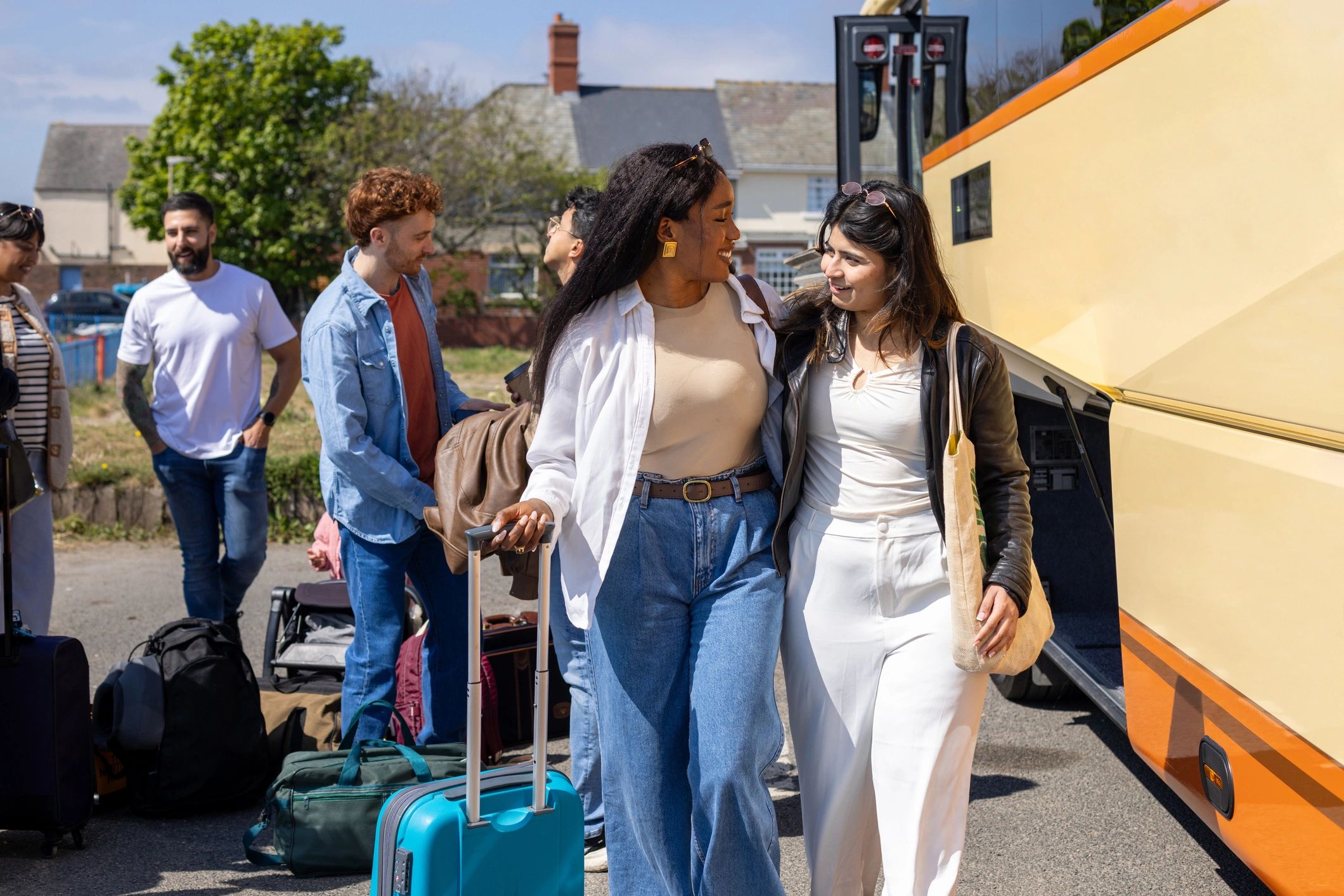 Travelers with luggage near a coach